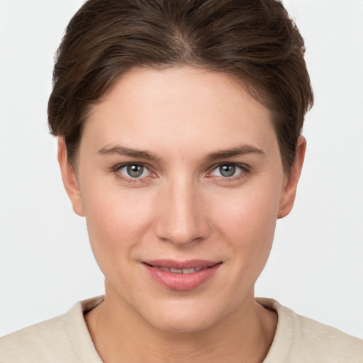 Joyful white young-adult female with short  brown hair and grey eyes