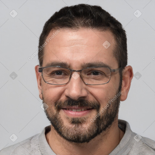 Joyful white adult male with short  black hair and brown eyes