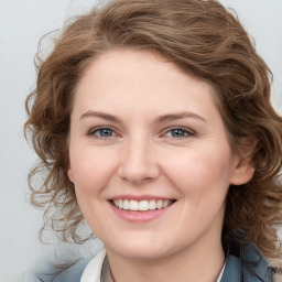 Joyful white young-adult female with medium  brown hair and blue eyes