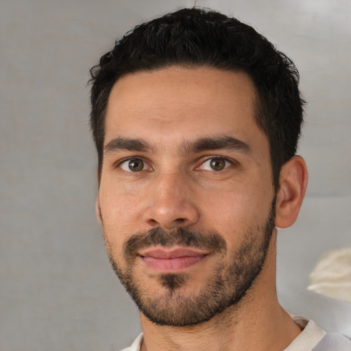 Joyful white young-adult male with short  black hair and brown eyes