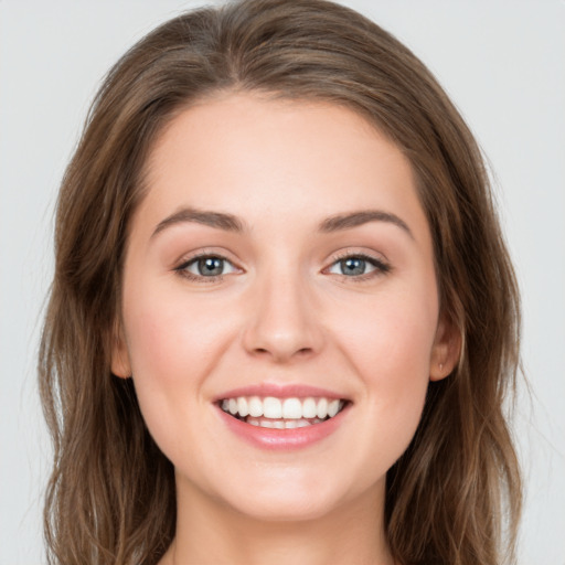 Joyful white young-adult female with long  brown hair and green eyes