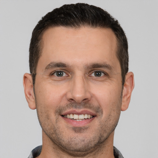 Joyful white adult male with short  brown hair and brown eyes