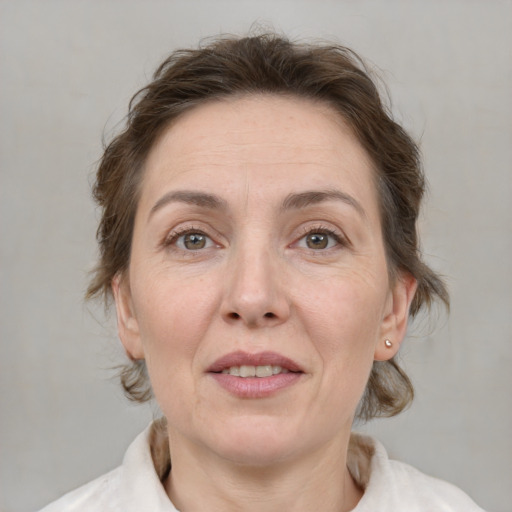 Joyful white adult female with medium  brown hair and grey eyes