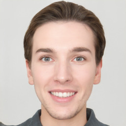 Joyful white young-adult male with short  brown hair and grey eyes