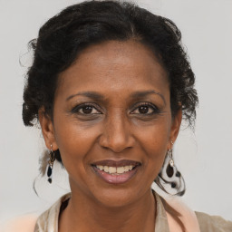 Joyful black adult female with medium  brown hair and brown eyes