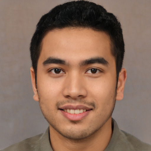 Joyful latino young-adult male with short  brown hair and brown eyes