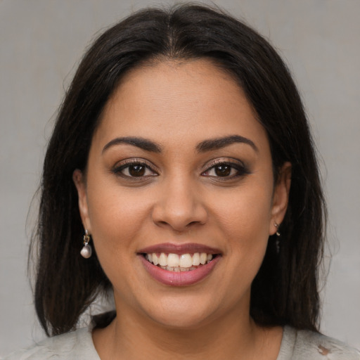 Joyful latino young-adult female with medium  brown hair and brown eyes
