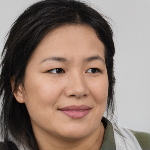 Joyful asian adult female with medium  brown hair and brown eyes