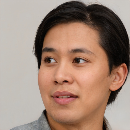 Joyful asian young-adult male with medium  brown hair and brown eyes