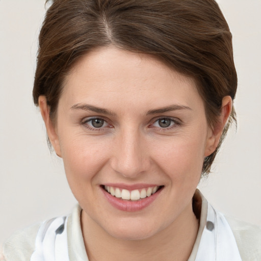 Joyful white young-adult female with medium  brown hair and grey eyes