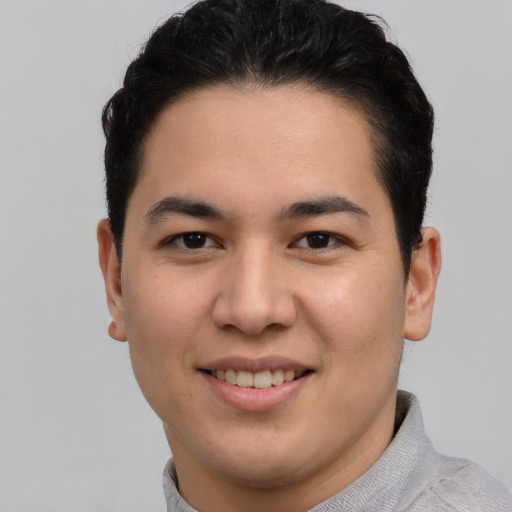 Joyful latino young-adult male with short  brown hair and brown eyes