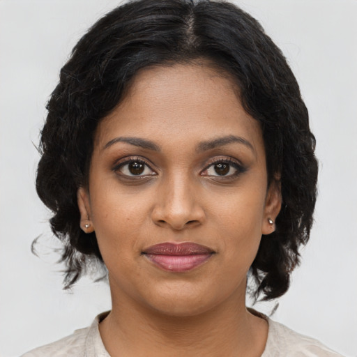 Joyful black young-adult female with medium  brown hair and brown eyes