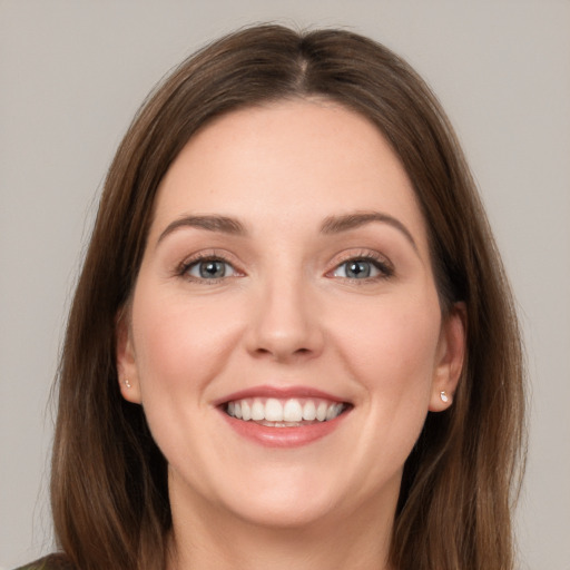 Joyful white young-adult female with long  brown hair and grey eyes