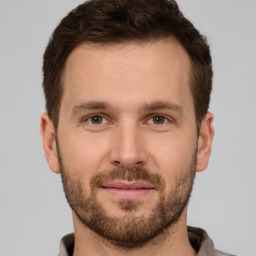 Joyful white young-adult male with short  brown hair and grey eyes