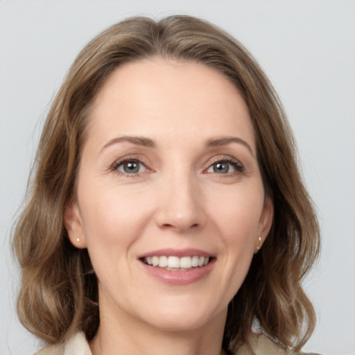 Joyful white adult female with medium  brown hair and grey eyes