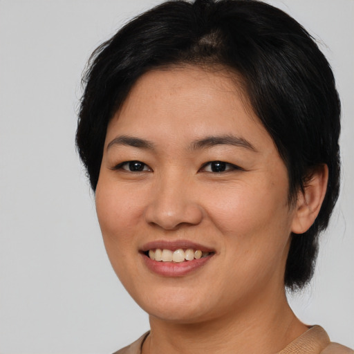 Joyful asian young-adult female with medium  black hair and brown eyes