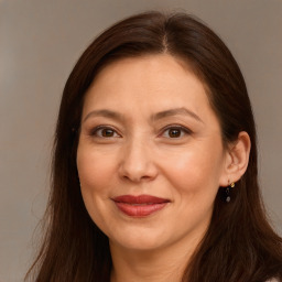 Joyful white adult female with long  brown hair and brown eyes