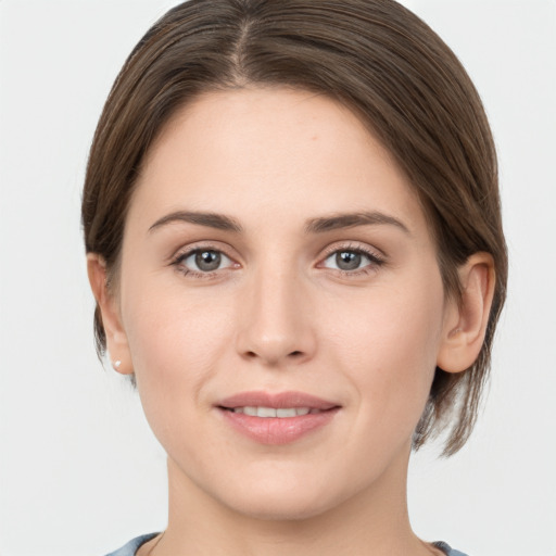 Joyful white young-adult female with medium  brown hair and grey eyes