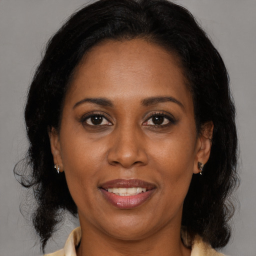 Joyful black adult female with medium  brown hair and brown eyes