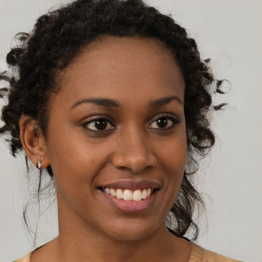 Joyful black young-adult female with medium  brown hair and brown eyes