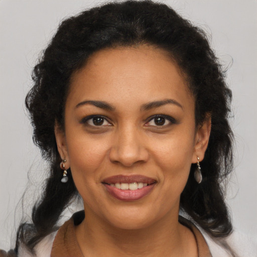 Joyful black adult female with long  brown hair and brown eyes