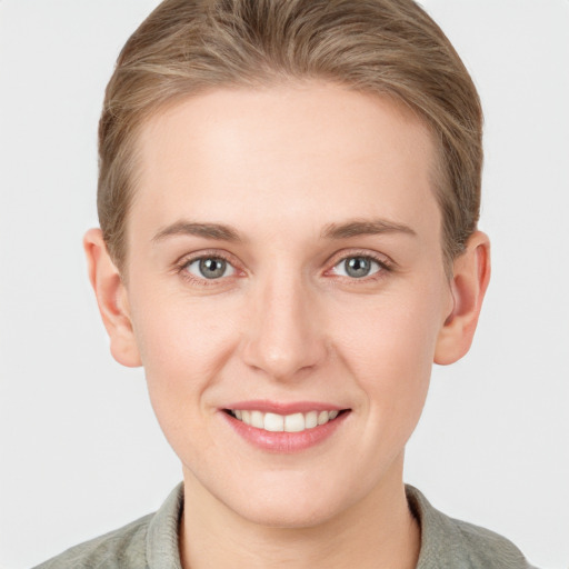 Joyful white young-adult female with short  brown hair and blue eyes