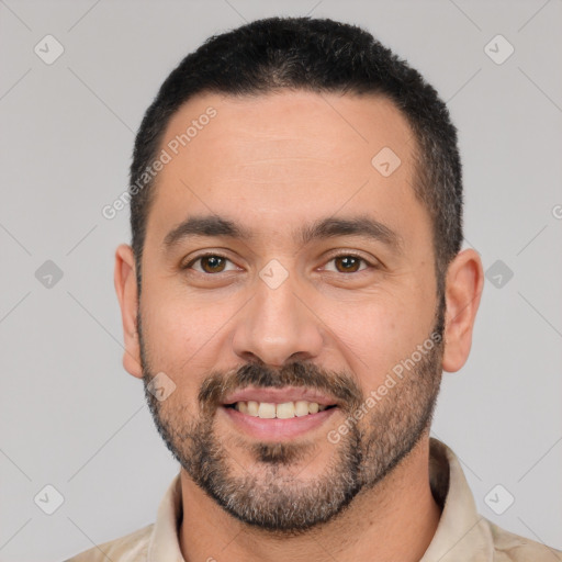 Joyful white adult male with short  black hair and brown eyes