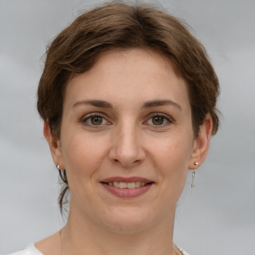 Joyful white young-adult female with short  brown hair and grey eyes