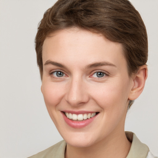 Joyful white young-adult female with short  brown hair and grey eyes