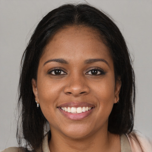 Joyful black young-adult female with medium  brown hair and brown eyes