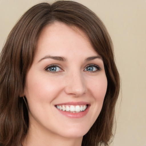 Joyful white young-adult female with long  brown hair and green eyes