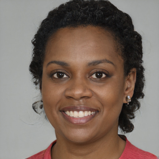 Joyful black young-adult female with medium  brown hair and brown eyes