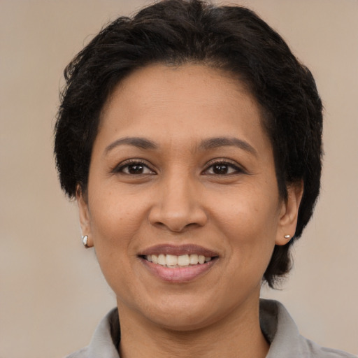 Joyful latino adult female with medium  brown hair and brown eyes