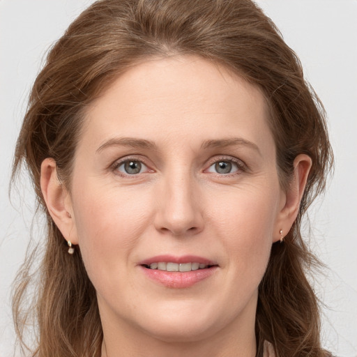 Joyful white young-adult female with long  brown hair and grey eyes