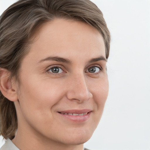 Joyful white young-adult female with medium  brown hair and grey eyes