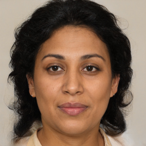 Joyful latino adult female with medium  brown hair and brown eyes