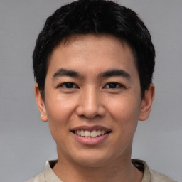 Joyful asian young-adult male with short  black hair and brown eyes