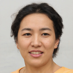 Joyful asian young-adult female with short  brown hair and brown eyes