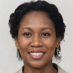 Joyful black adult female with medium  brown hair and brown eyes