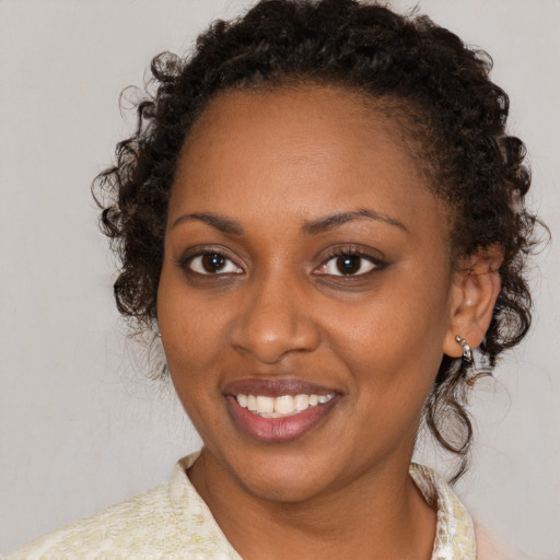 Joyful black adult female with medium  brown hair and brown eyes