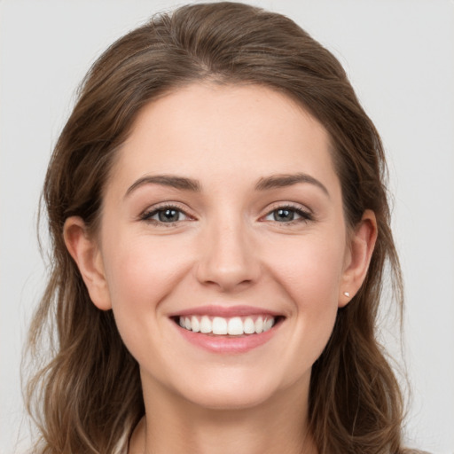 Joyful white young-adult female with long  brown hair and grey eyes