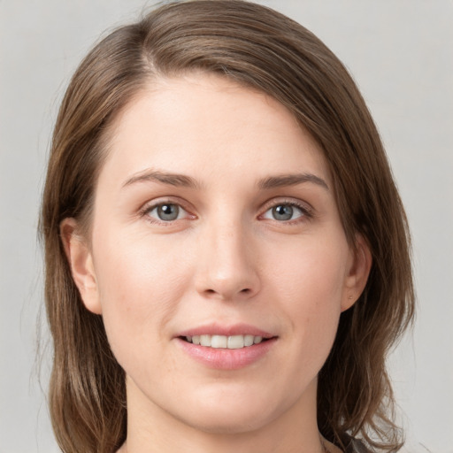 Joyful white young-adult female with medium  brown hair and grey eyes