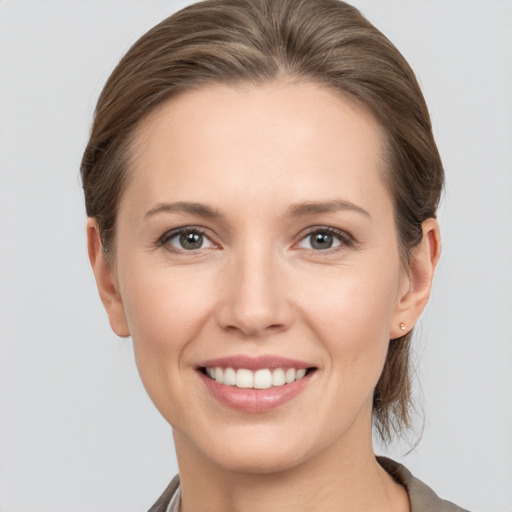 Joyful white young-adult female with medium  brown hair and grey eyes