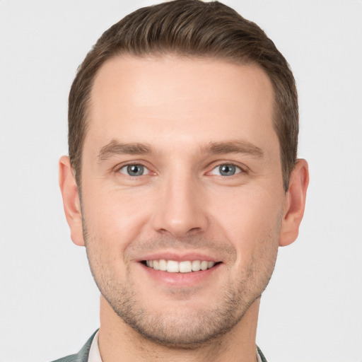 Joyful white young-adult male with short  brown hair and grey eyes