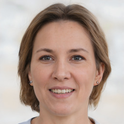 Joyful white adult female with medium  brown hair and grey eyes