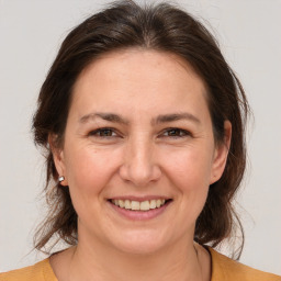 Joyful white adult female with medium  brown hair and brown eyes