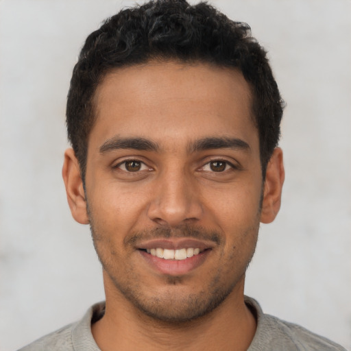 Joyful latino young-adult male with short  black hair and brown eyes