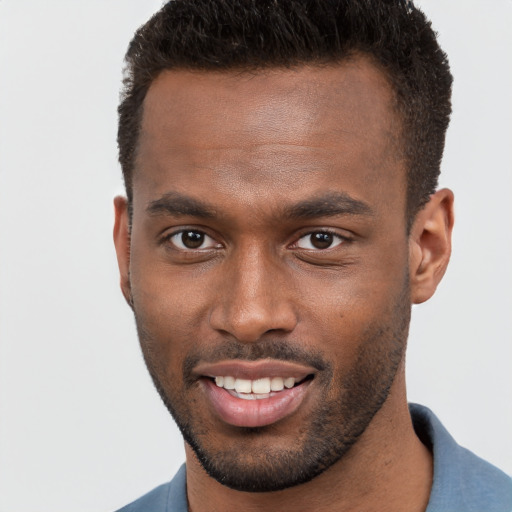 Joyful black young-adult male with short  brown hair and brown eyes