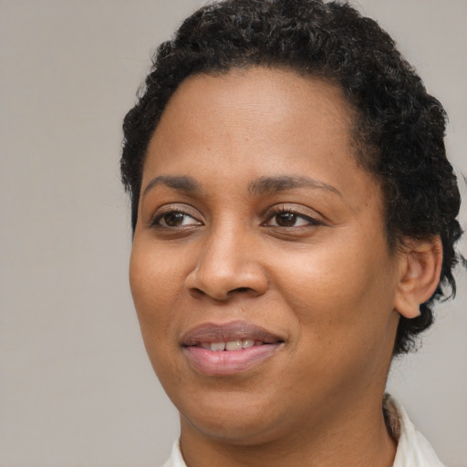 Joyful black young-adult female with short  brown hair and brown eyes