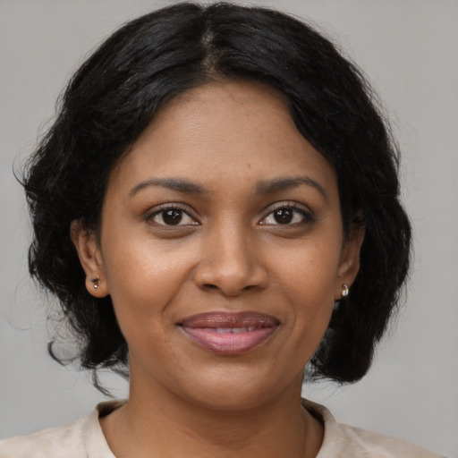 Joyful black young-adult female with medium  brown hair and brown eyes